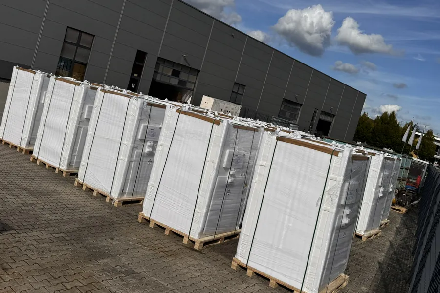 Reihe verpackter Batteriespeicher auf Paletten vor der Lagerhalle in Ibbenb&uuml;ren
