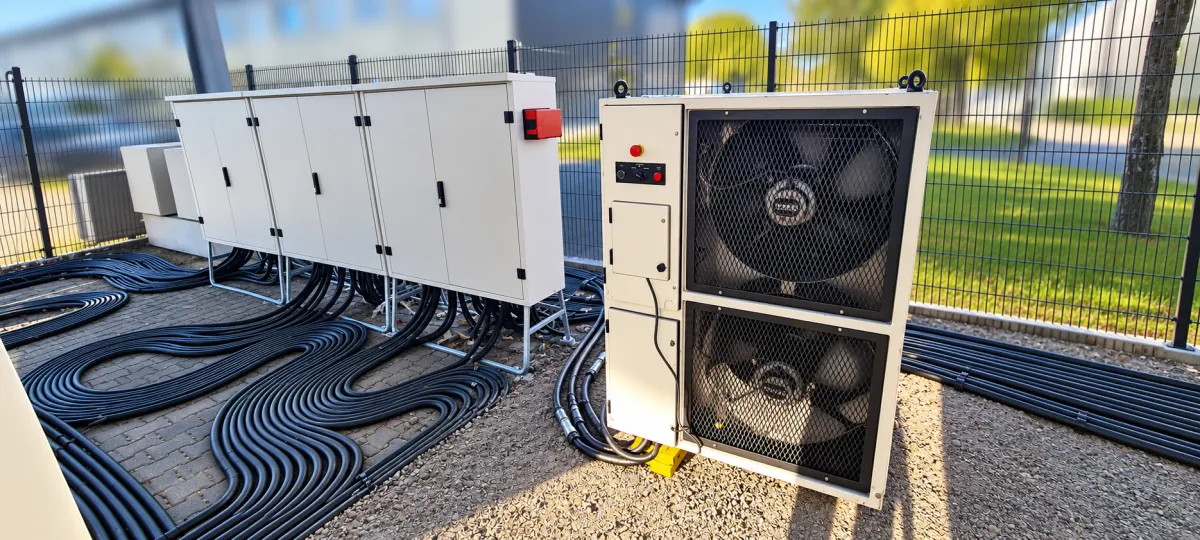 Lastbank mit zwei großen Lüftern neben einer Reihe Schaltschränke, Kabel sauber verlegt